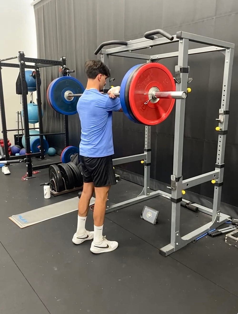 A YF Volleyball athlete strength training in the squat rack